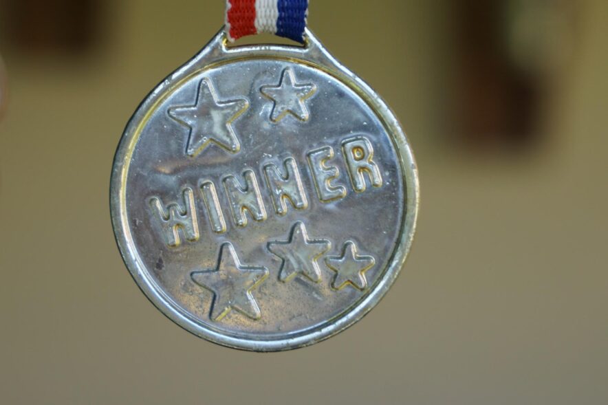 close up of a medal embossed with stars and the word 'winner'